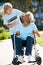 Volunteer Pushing Senior Woman In Wheelchair