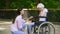 Volunteer talking with crying woman in wheelchair, psychological support, park