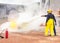 Volunteer using fire extinguisher from hose for fire fighting during basic fire fighting training evacuation