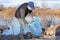 A volunteer wearing a protective mask collects empty bottles. The concept of ecology and environmental protection