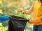 Volunteer women collect plastic water bottles in the park area, From people who refuse to throw in the trash into bag for