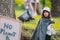 Volunteer work outdoors to keep the planet clean and save, young girl in protective gloves holding the garbage bag on