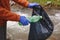 volunteer young woman collecting garbage, picking up waste, land and water pollution