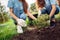 Volunteering. Young people volunteers outdoors planting tree together close-up