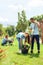 Volunteering. Young people volunteers outdoors planting trees boy helping girl digging plant from pot cheerful