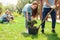 Volunteering. Young people volunteers outdoors planting trees boy helping girl digging plant from pot happy close-up