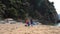 Volunteers with dogs carry bags with garbage along beach