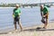 Volunteers gathering garbage on river bank. Ecology concept