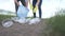 Volunteers group of people collects plastic trash in the park on the road. recycle plastic bottle cleanup ecology