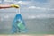 Volunteers hand in yellow rubber glove holding trash bag against sea and sky while cleaning the beach plastic waste and