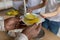 Volunteers help. Young people serving hot soup for homeless in community charity donation center, closeup