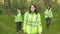 Volunteers rescuers in green vests are searching for a missing person in the woods at sunset