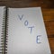 Vote, handwriting  text on paper, political message. Political text on office agenda. Concept of democracy, voting, politics. Copy