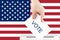 Voting in the usa, a hand with a ballot against the background of the american flag puts the vote in the ballot box, congressional