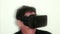 VR: CU man wears virtual reality gaming headset and reacts to action