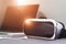 VR headset with earphone and laptop on sofa