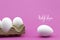 Vrolijk Pasen, Happy Easter white eggs in an egg carton on a pink background.