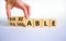 Vulnerable or variable symbol. Businessman turns wooden cubes and changes the word Vulnerable to Variable. Beautiful white