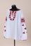 Vyshyvanka Ukrainian national outfit. White textile embroidered shirt on a black manikin. Vyshyvanka with large red