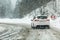 Vysna Boca, Slovakia - January 08, 2019: Car drives through heavy snowstorm on forest road, in sharp curve. Driving conditions are