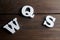 W, S and Q letters white wooden letters on dark wooden background