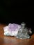 Wabi Sabi Metal Buddha in front of an Amethyst Crystal on a Wooden Table