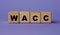 WACC - acronym on wooden cubes on a lilac background