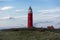 Wadden Sea island Texel on a beautiful evening with the famous red light house and the small house next to it