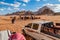 Wadi Rum desert, people, camels, cars at safari