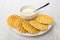 Wafer cookies, bowl with condensed milk, spoon in white plate