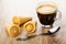 Wafer horns with cream, cup with black coffee, spoon on table