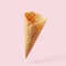 Wafer ice cream cone on a light pink background. Minimalistic concept