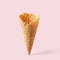 Wafer ice cream cone on a light pink background. Minimalistic concept