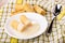 Wafer rolls with condensed milk in saucer, wafer rolls on napkin on table