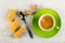 Wafer rolls, spoon, sugar, cup with coffee on saucer on wooden table. Top view