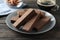 Wafers, cup of coffee and almond on table, close up