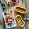 Waffle boat ice cream sundae topped with maraschino cherries and chocolate sauce