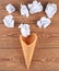 Waffle horn and balls of crumpled paper on a wooden surface. Creative layout, minimal trend.