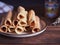 Waffle tubes on a ceramic plate on a wooden table.