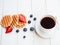 Waffles, blueberries, strawberries, hot coffee on the old wooden background
