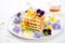 waffles with edible flowers and honeycomb, elegant plating