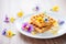 waffles with edible flowers and honeycomb, elegant plating