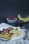 Waffles with fresh banana, raspberries, blueberries for breakfast. Belgian waffles. Dark wooden background