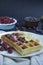 Waffles with fresh banana, raspberries, blueberries for breakfast. Belgian waffles. Dark wooden background