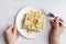 waffles plate with banana slices hand holding fork. High quality photo