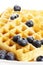 Waffles with sugar covered blueberries and syrup