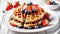 Wafles with syrup on white plate with fruits.