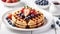 Wafles with syrup on white plate with fruits.