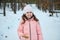 Waist length portrait of happy kid, charming pleasant 5 years old Caucasian baby girl snacking outdoor while walking on a snow