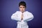 Waist length portrait of a strong European teenage boy, aikido fighter practicing martial skills against violet wall background,